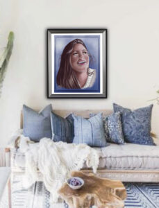 "Joy in the Moment", Digital Painting. A woman with long brown hair and brown eyes wearing a cream cowl neck sweater is smiling and looking up into a clear blue winter sky. Painting displayed framed on a wall above a white couch with blue throw pillows. Shadowmyst Art.
