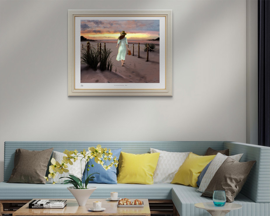 Beach sunset painting of a woman in a white dress walking a sandy shoreline path at dusk, by Shadowmyst Art displayed framed on an off white wall above a blue couch.